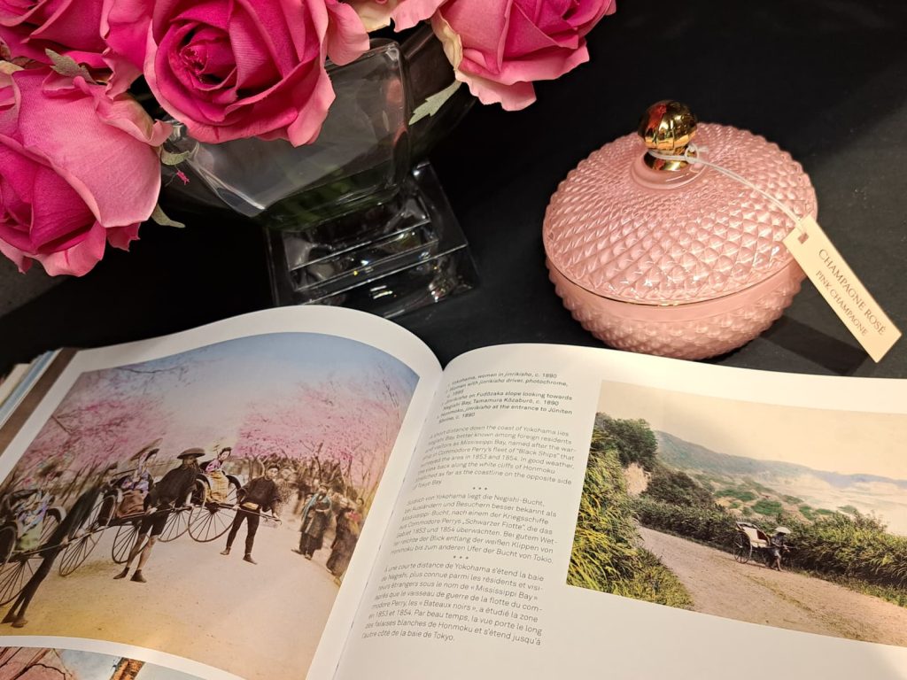 Bodegón de elaboración propia que incluye una vela rosa, un ramo de rosas fuxias y un libro de arte e historia.